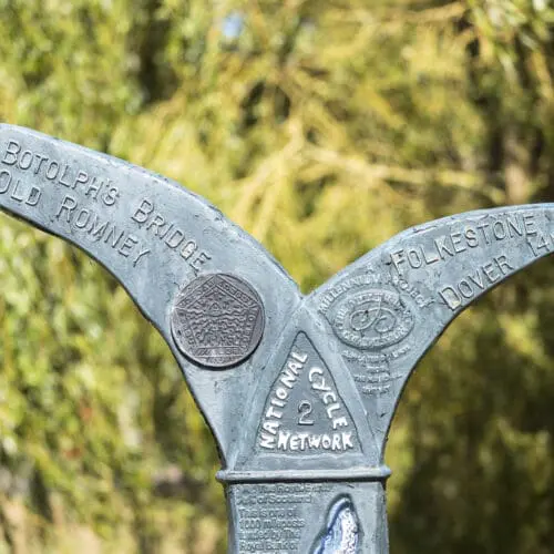 Blue signpost with two curves forking in opposite directions from its top. The middle has a triangle with 'National Cycle Network 2' written.