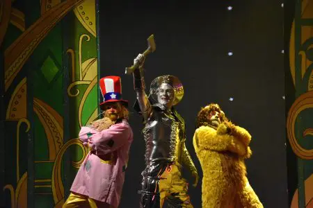 A scarecrow, tinman and Lion posing on stage.