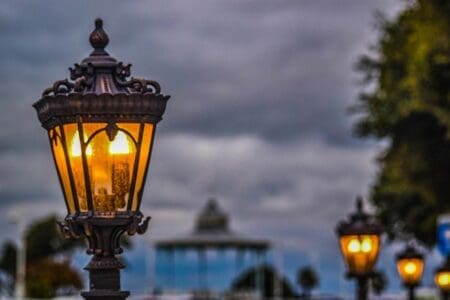 A black streetlight lit up with others in the background