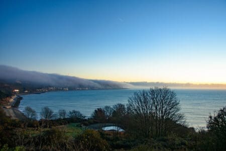 A view over the sea with blue sky and low clouds