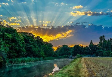 A canal stretches into the district as the sun rises behind it.