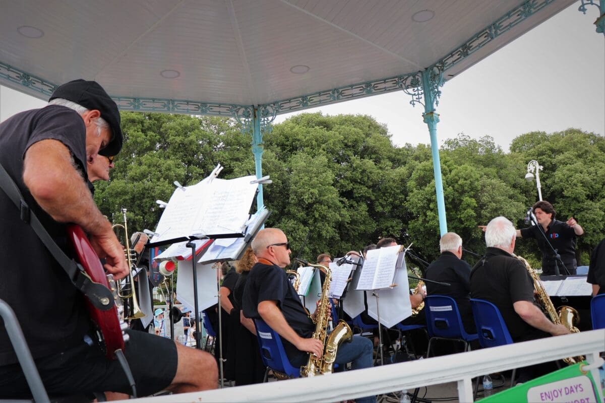 Musicians playing instruments together on a bandstand