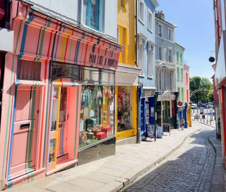A row of colourful shops in a narrow cobbled street