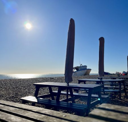 Bench tables on a shingle beach