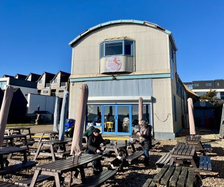 A couple at tables in front of a warehouse type buidling